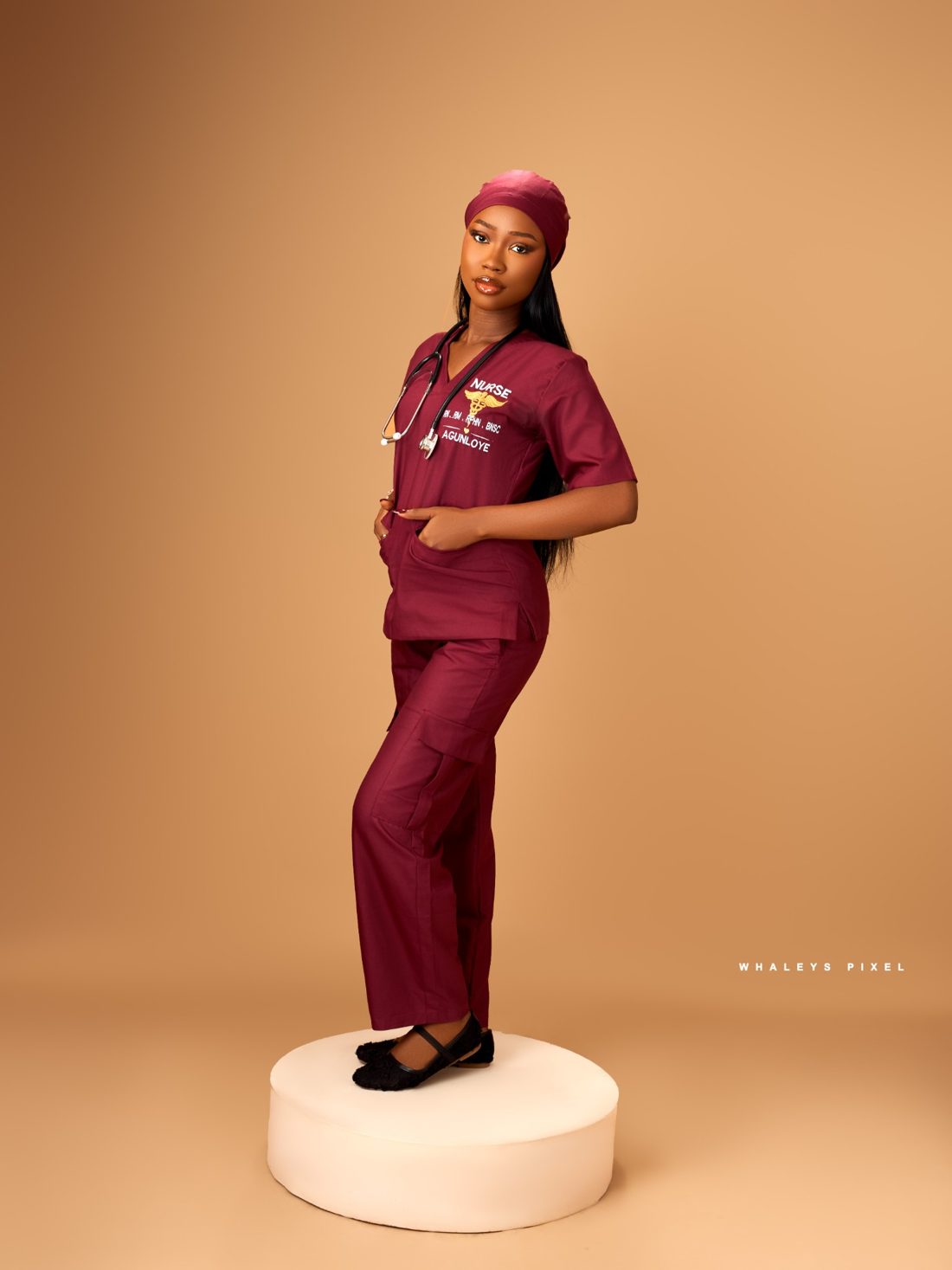 Victoria posing in scrubs on a studio podium